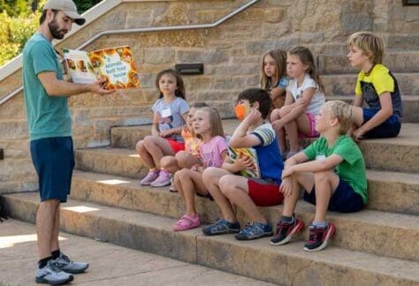 kids listening to story being read outside